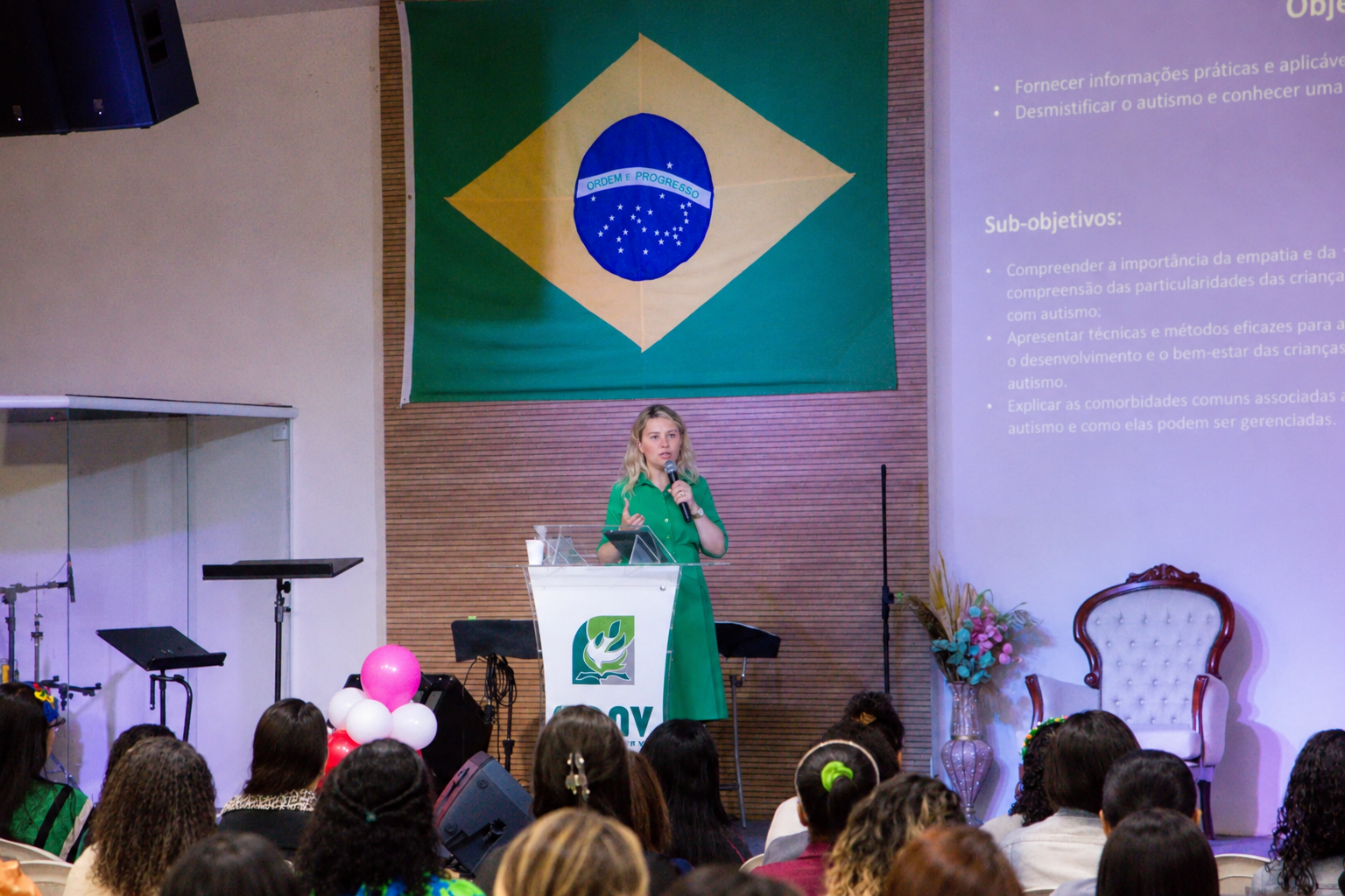 Lorena Jacob ministrando uma palestra presencial diante do público