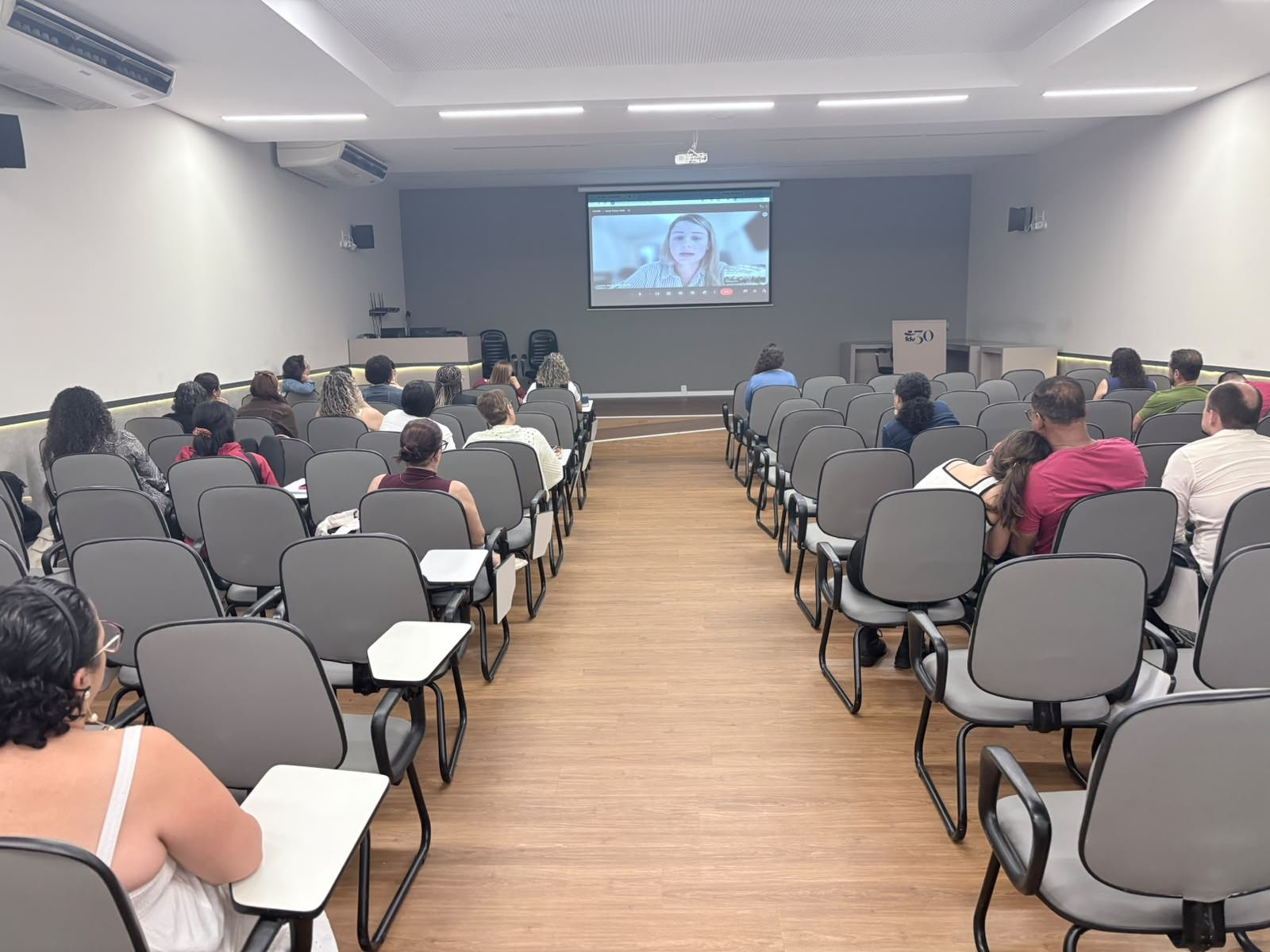 Auditório acompanhando uma participação on-line de Lorena Jacob